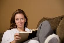 Kvinna sitter i soffan och läser